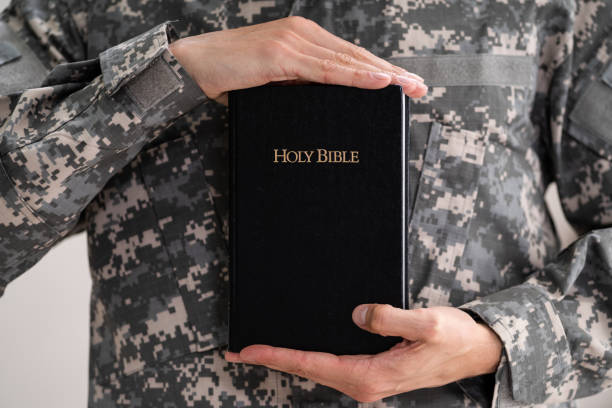 солдат отечественной военной армии, держащий библию - armed forces praying us military military стоковые фото и изображения