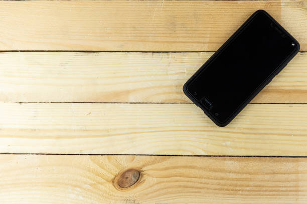 istock the smartphone is lying on a wooden surface 1250692458