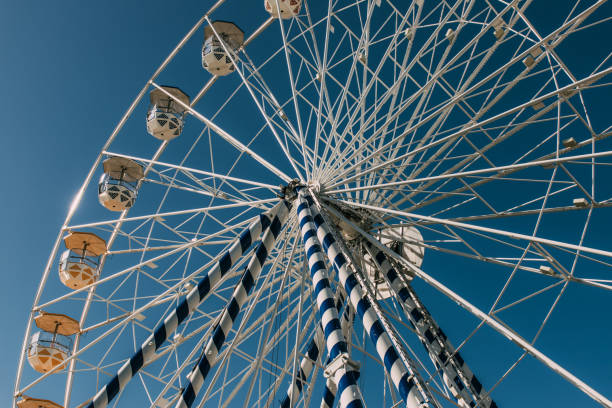 istock low angle view of ferris wheel against blue sky in summertime 1250694121