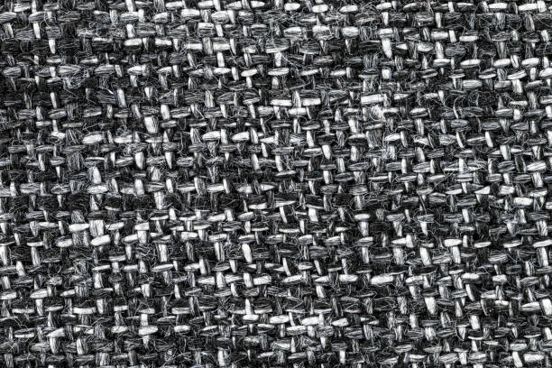 Macro shot of a white and black fabric with an interwoven pattern of horizontal and vertical lines.