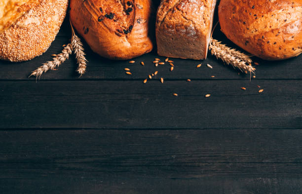 istock Bread border on dark wood background with copy space. Different kinds of bread. Bakery, cooking and grocery store concept. 1250699549