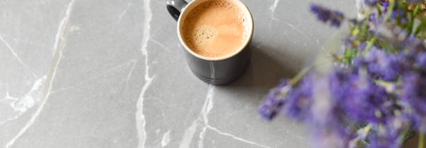 istock Coffee drink and flowers on a marble table in home interior 1250699612