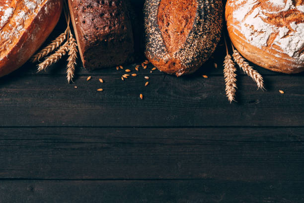 istock Bread border on dark wood background with copy space. Different kinds of bread. Bakery, cooking and grocery store concept. 1250699733