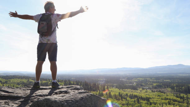 istock Hiker relaxes with arms spread on mountain ridge 1250700847