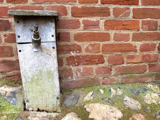istock Water tap in wooden box secured into a stone and concrete footpath 1250713331