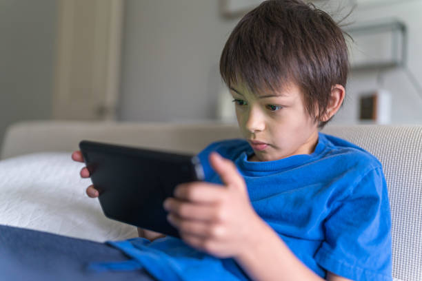 istock Nine-year old ethnic boy plays game on phone 1250718141