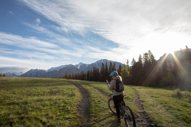 istock Female mountain e-biker checks cell phone for directions 1250719497