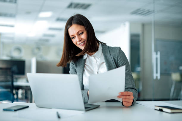 istock Portrait of a cheerful entrepreneur working with laptop and documents. 1250720961