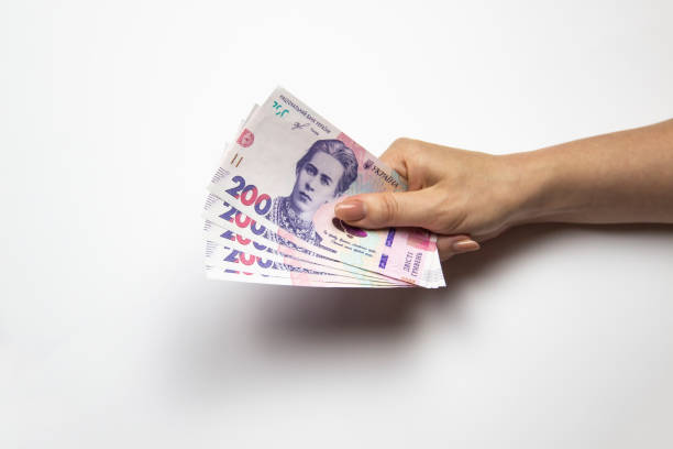 Female hand holds a thousand hryvnia. Ukrainian currency with woman's hand against a white background. One thousand hryvnia with two hundred hryvnia five bills. Ukrainian money.  Banknotes of Ukraine Female hand holds a thousand hryvnia. Ukrainian currency with woman's hand against a white background. One thousand hryvnia with two hundred hryvnia five bills. Ukrainian money.  Banknotes of Ukraine ukrainian currency stock pictures, royalty-free photos & images