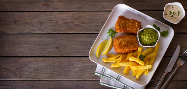 istock Fish and chips served with lemon, mushy peas and sauce. 1250722146