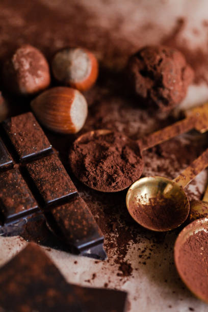 istock Delicious homemade chocolate preparation process. Vintage copper kitchen tableware sprinkled with cocoa powder. Intense brown color, aromatherapy. Dark and moody, macro, flat lay, top view 1250724405