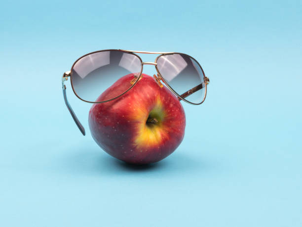 istock Glasses on ripe Apple on a blue background. 1250726810