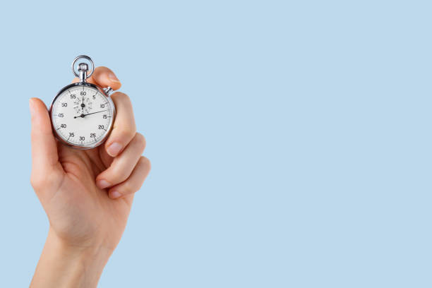 istock stopwatch hold in hand, button pressed,monochromatic light blue  background 1250731171