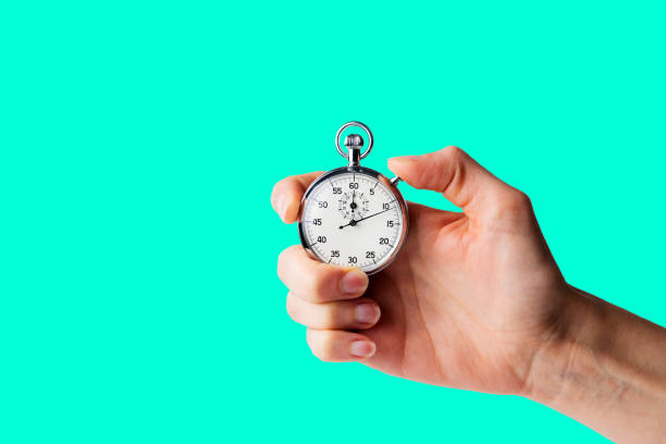 istock stopwatch hold in hand, button pressed, monocromatic aqua menthe background 1250731191