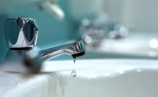 nahaufnahme von wassertropfen aus hahn im öffentlichen badezimmer - washtub stock-fotos und bilder