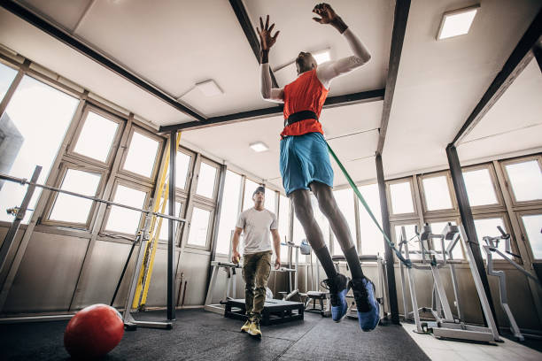 istock One man volleyball player training in the gym with a personal trainer 1250732286