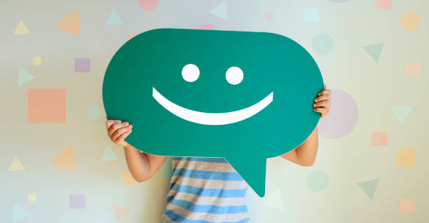 istock Boy holding chat bubble with happy face emoji over 1250735851