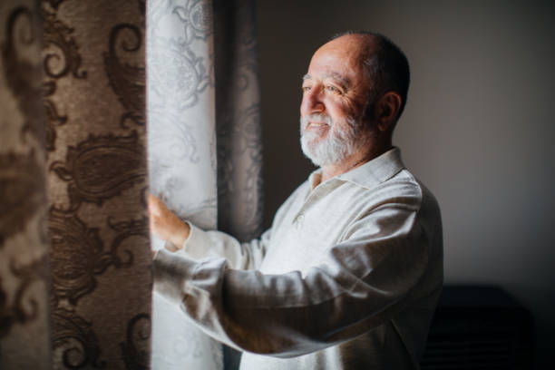 istock Happy senior men opens the curtains 1250736322