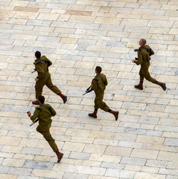 East Jerusalem, Palestine, May 2, 2019: Israeli soldiers rush to meeting to receive instructions on the protection of the most sacred place of the Jews - the Western Wall.