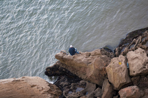 Rabat, Morocco - November 09, 2016: Man sitting on a rock fishing