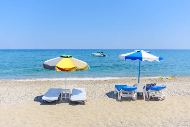 istock Empty sunbeds with umbrellas on Stegna beach (RHODES, GREECE) 1250739681