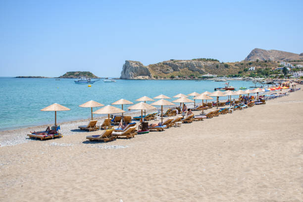istock Stegna beach with sunbeds and umbrellas, holidaymakers sun bathing (RHODES, GREECE) 1250739682