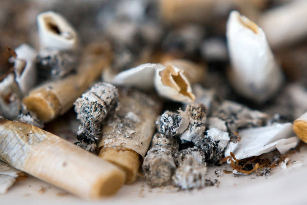 istock Closeup of old cigarette butts lying in a full ashtray. 1250739706