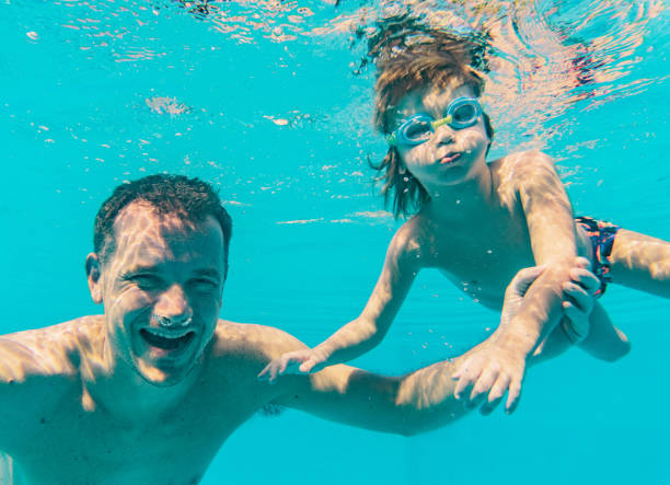 istock Father and child in swimming pool 1250739886