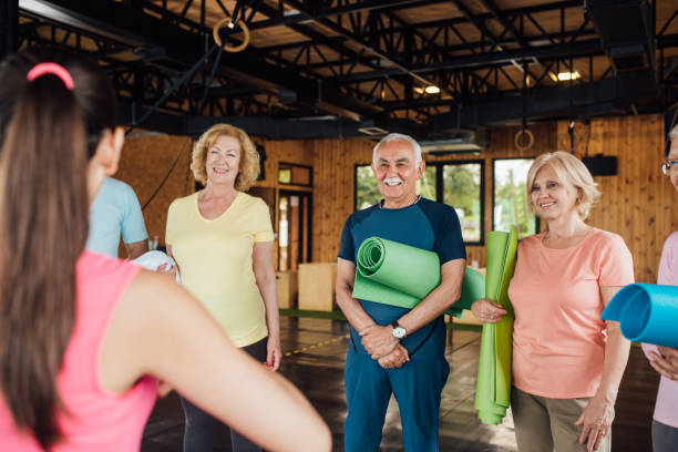 istock Young instructor introducing yoga to a senior group 1250775932