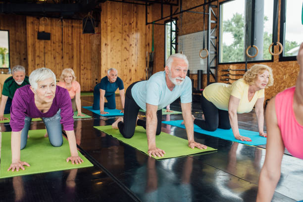 istock Seniors doing cat-cow exercise on their group yoga class 1250776460
