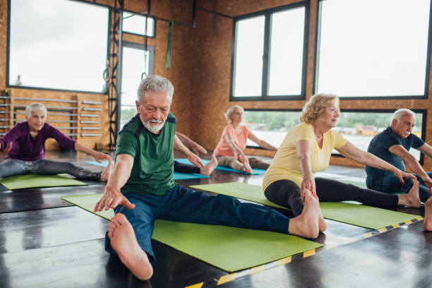 istock Group of seniors stretching legs on yoga class 1250776469