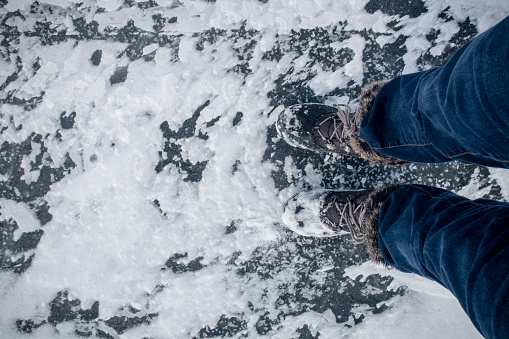 A shot of feet standing on a frozen lake from above
