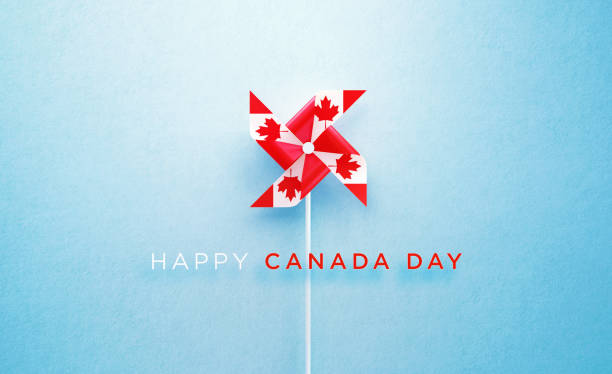 happy canada day nachricht und papier pinwheel strukturiert mit kanadischen flagge auf blauem hintergrund - canada day fotos stock-fotos und bilder