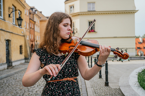 A musician playing a classical music instrument outdoors, the violin is used to play classical music