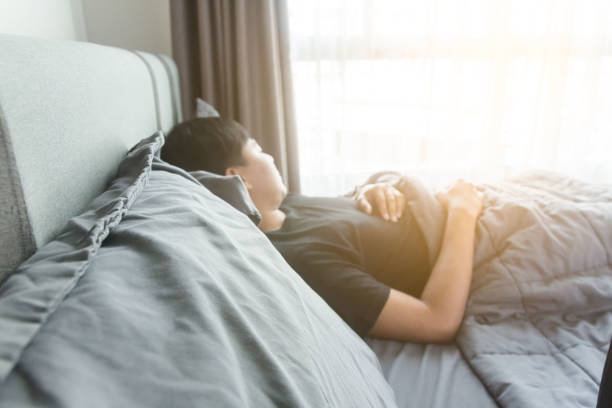 istock Handsome male sleeping in bed in a hotel room 1250837654