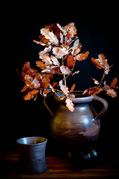 istock Still life with an old jug and dry oak leaves. 1250886774