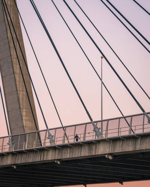 istock A person takes a walk along a suspended cable bridge at dusk 1250908281
