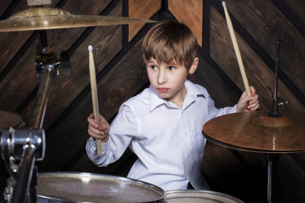 istock The child plays the drums. Boy musician behind a drum kit. 1250908430