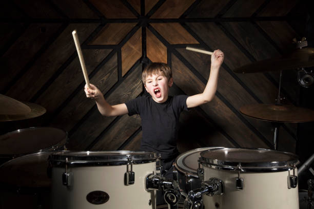 istock The child plays the drums. Boy musician behind a drum kit. 1250908455