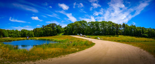 paysage vert de champ d’été de panorama avec le chemin de terre incurvé autour de l’étang - massachusetts landscape new england spring photos et images de collection