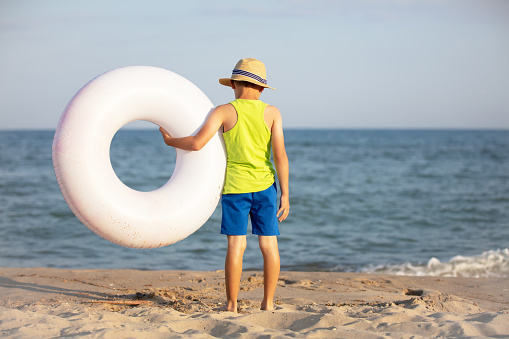 Child at sea. Boy with an rubber ring on the seashore.