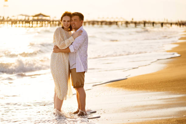 istock couple stand on shore line, sandy beach. romantic relationship, travel together. 1250914521