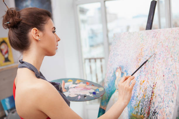istock Young female artist painting at her workshop 1250914827