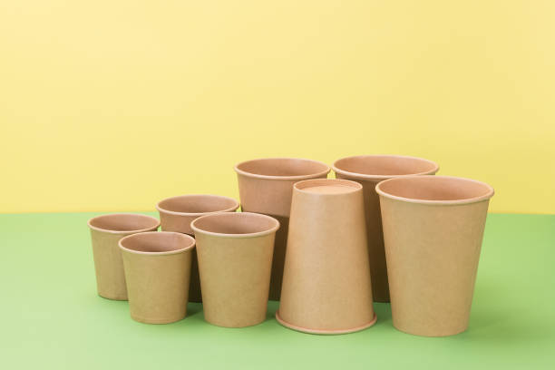 istock Paper disposable tableware on yellow and green background. 1250914828
