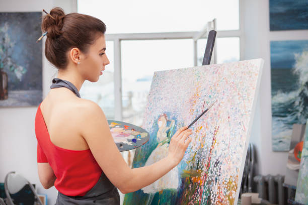 istock Young female artist painting at her workshop 1250914837