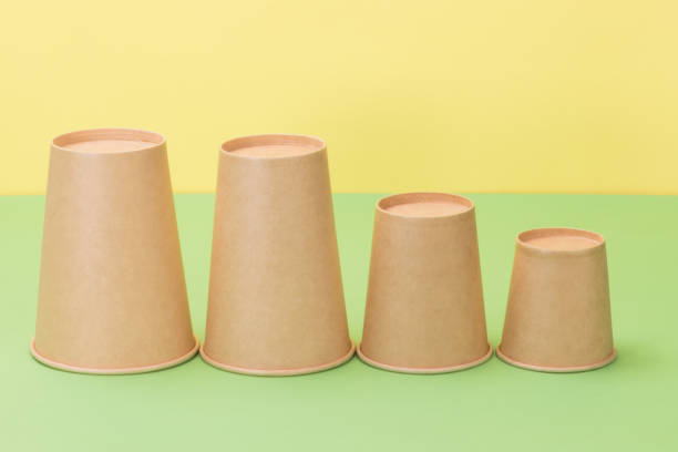 istock Paper cups in yellow and green background. 1250914838