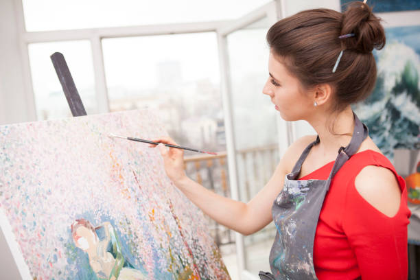 istock Young female artist painting at her workshop 1250914863