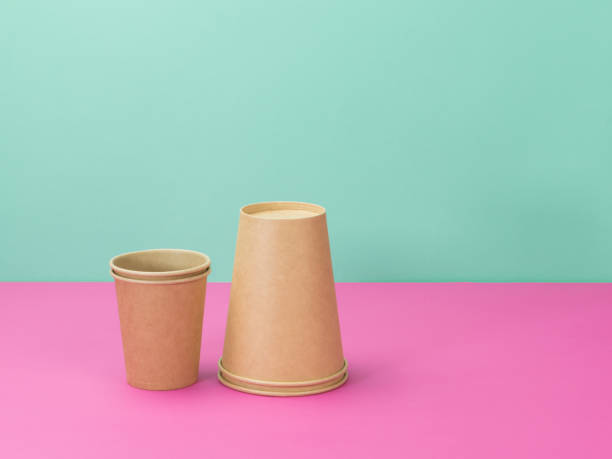 istock Disposable paper cups on a pink and turquoise background. 1250914927