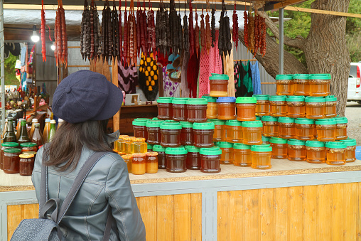 Female traveler in front of a souvenir stand with local products of Georgia, ( Self Portrait )