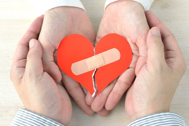 manos de pareja con el corazón roto con yeso adhesivo - reconciliarse fotografías e imágenes de stock